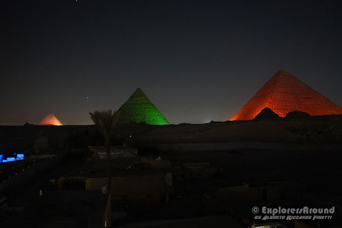 le piramide viste da una posizione previlegiata illuminate di notte a Giza Egitto explorers around